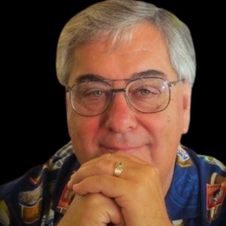 male in printed shirt with grey hair and glasses and ring in black ground